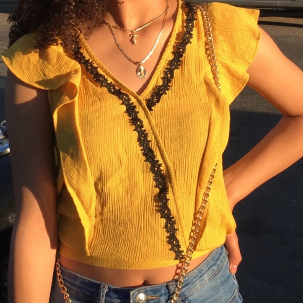 A mustard color shirt with black detail